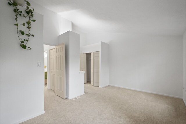 unfurnished room featuring light carpet and high vaulted ceiling