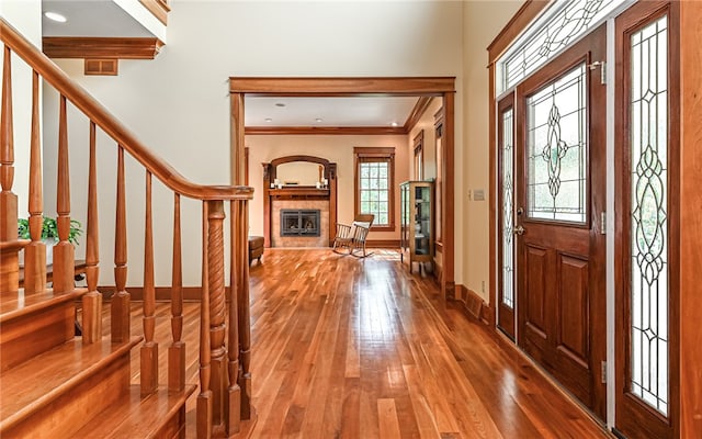 entryway with ornamental molding and hardwood / wood-style floors