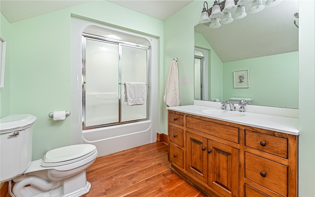 full bathroom featuring enclosed tub / shower combo, vanity, toilet, hardwood / wood-style flooring, and vaulted ceiling