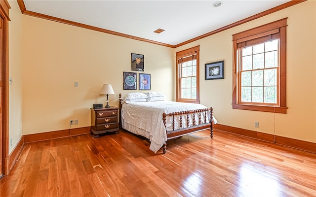 bedroom with crown molding and hardwood / wood-style floors