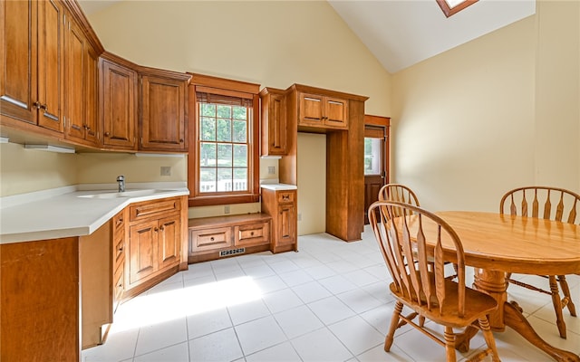 kitchen featuring light tile patterned flooring, sink, and high vaulted ceiling