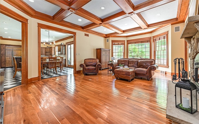 living room featuring crown molding, light hardwood / wood-style flooring, and a chandelier