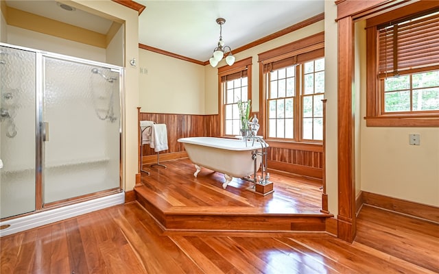 bathroom featuring shower with separate bathtub, hardwood / wood-style flooring, wood walls, an inviting chandelier, and ornamental molding