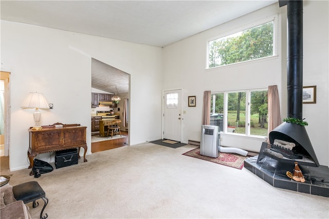 carpeted living room with vaulted ceiling and a healthy amount of sunlight