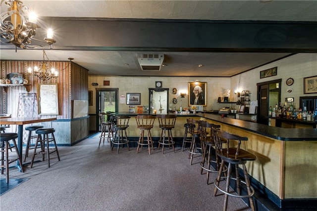 bar featuring a textured ceiling, a chandelier, and dark colored carpet