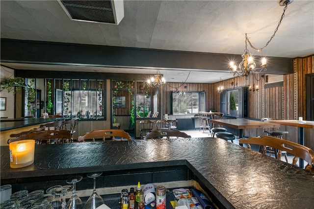 kitchen featuring a textured ceiling, an inviting chandelier, and decorative light fixtures