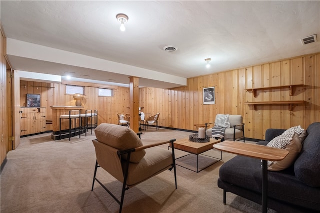 carpeted living room featuring wooden walls