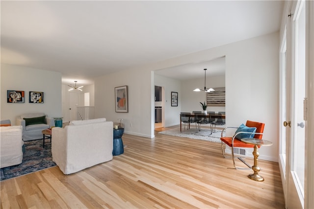 living room featuring an inviting chandelier and wood-type flooring