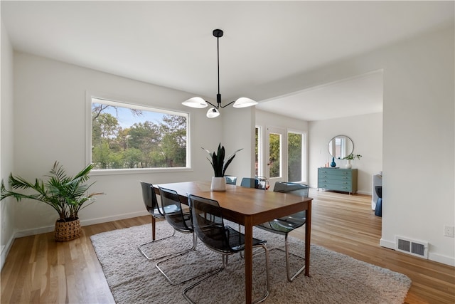 dining room with a notable chandelier and light hardwood / wood-style floors