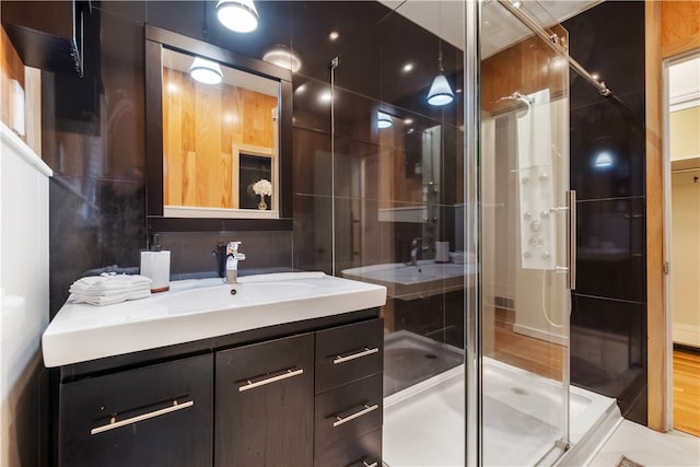 bathroom with hardwood / wood-style flooring, vanity, and an enclosed shower