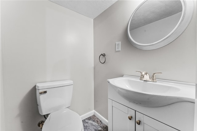 bathroom featuring vanity, a textured ceiling, and toilet