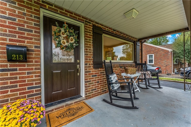 view of exterior entry featuring covered porch