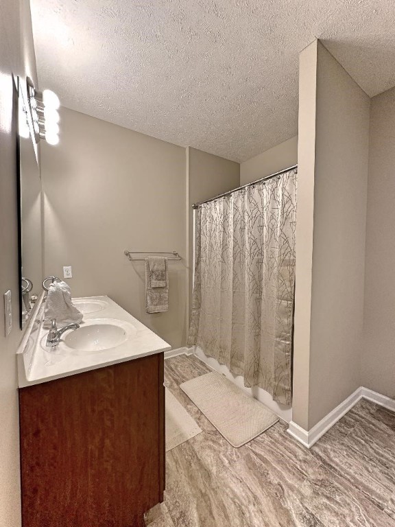 bathroom featuring a textured ceiling, vanity, hardwood / wood-style floors, and walk in shower