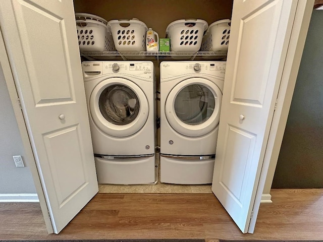 clothes washing area featuring separate washer and dryer and light hardwood / wood-style flooring