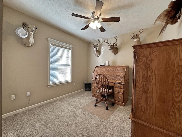 carpeted office space featuring ceiling fan and a textured ceiling