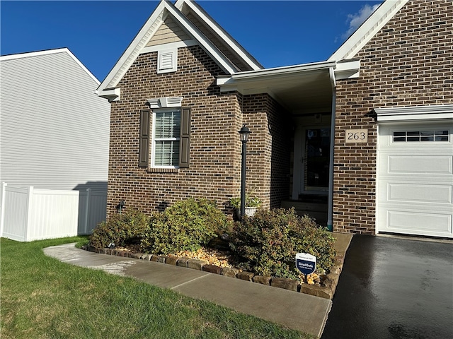 property entrance featuring a yard and a garage