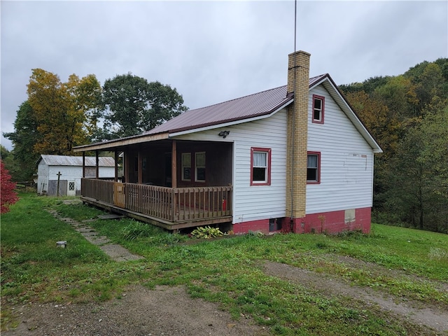 view of property exterior with a lawn and a deck