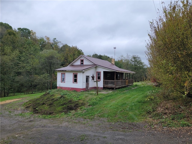 view of front of house with a wooden deck and a front lawn