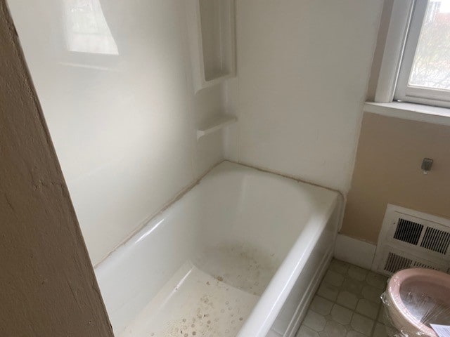 bathroom with a tub, tile patterned floors, and toilet