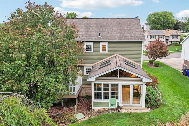 rear view of property featuring a lawn and a garage