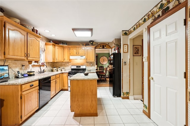 kitchen with decorative backsplash, light tile patterned flooring, black appliances, a center island, and sink