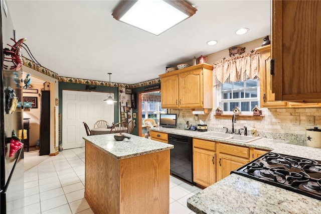 kitchen featuring black appliances, plenty of natural light, a kitchen island, and sink