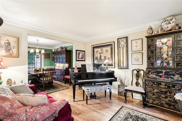 sitting room with an inviting chandelier, hardwood / wood-style floors, and ornamental molding