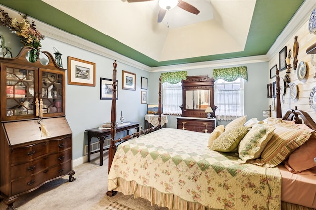 carpeted bedroom featuring ornamental molding, a tray ceiling, and ceiling fan