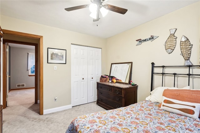 bedroom featuring light carpet, ceiling fan, and a closet