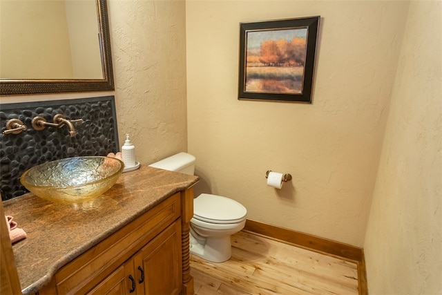 bathroom featuring vanity, wood-type flooring, and toilet