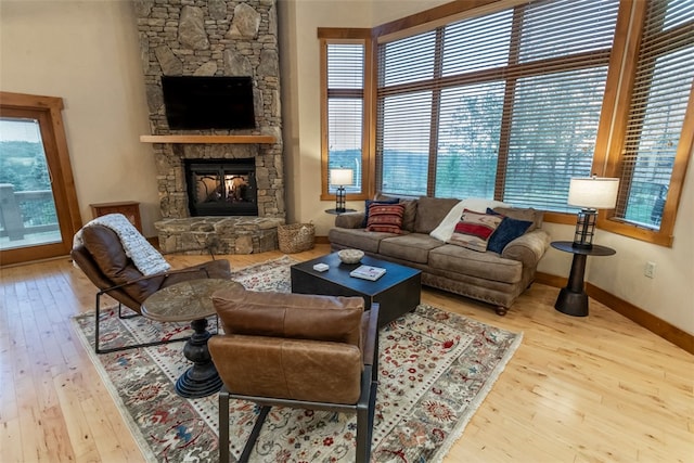 living room featuring light hardwood / wood-style floors and a stone fireplace