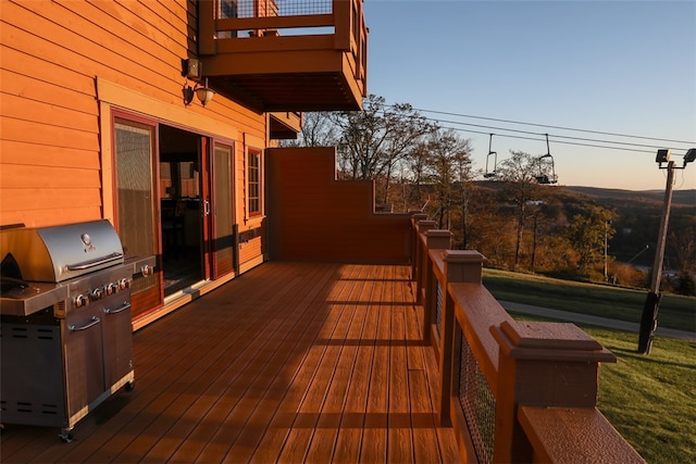 deck at dusk featuring grilling area