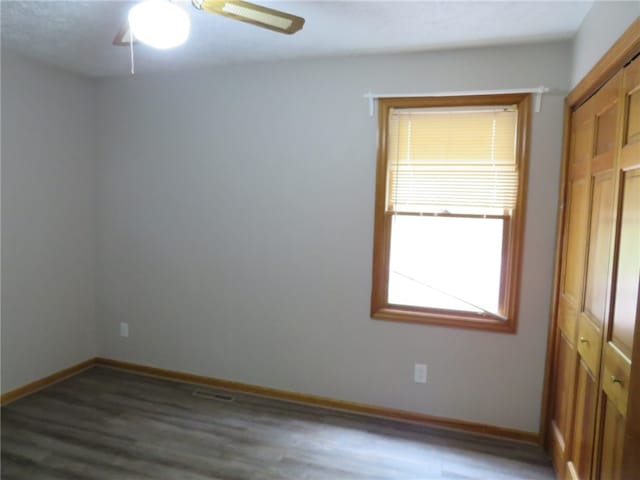 spare room featuring dark hardwood / wood-style floors and ceiling fan