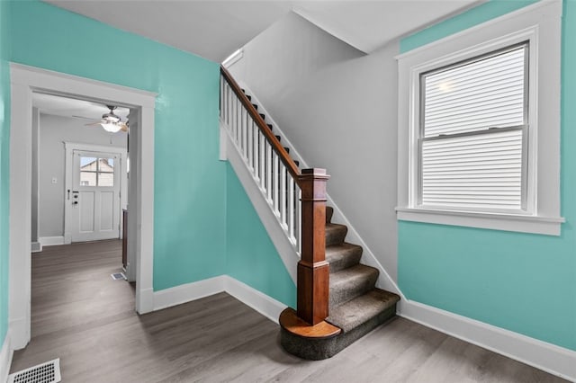 stairway with ceiling fan and hardwood / wood-style floors