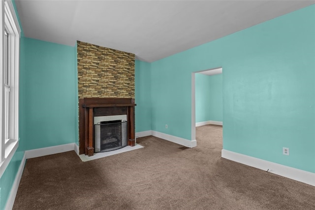 unfurnished living room with carpet floors and a large fireplace