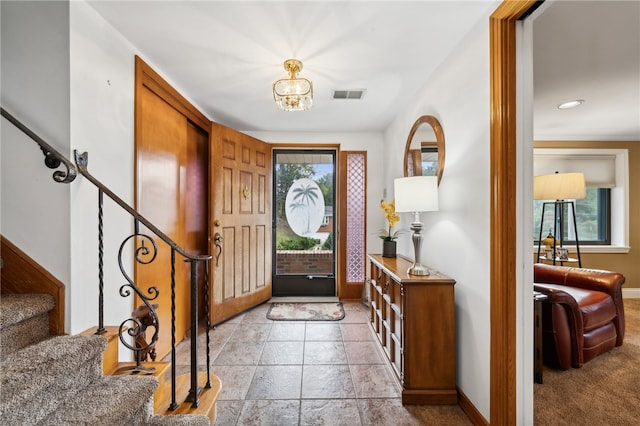 foyer entrance featuring an inviting chandelier and a healthy amount of sunlight