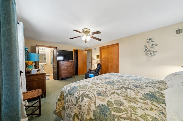 bedroom with ensuite bath, ceiling fan, and light colored carpet