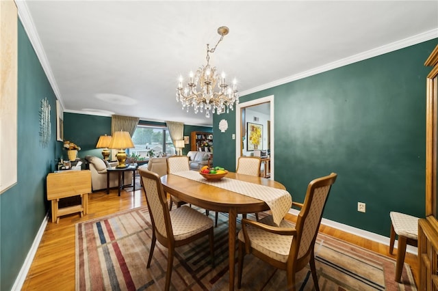 dining space with a notable chandelier, hardwood / wood-style flooring, and ornamental molding