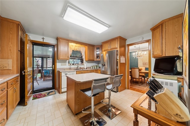 kitchen with dishwasher, a center island, sink, stainless steel refrigerator with ice dispenser, and an inviting chandelier