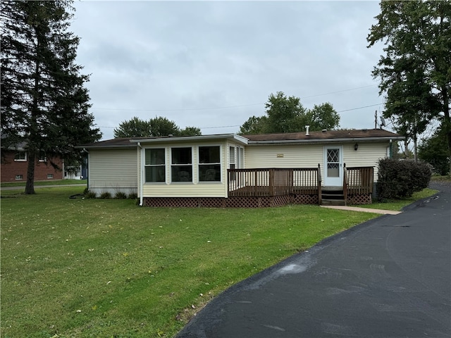 manufactured / mobile home with a deck and a front lawn