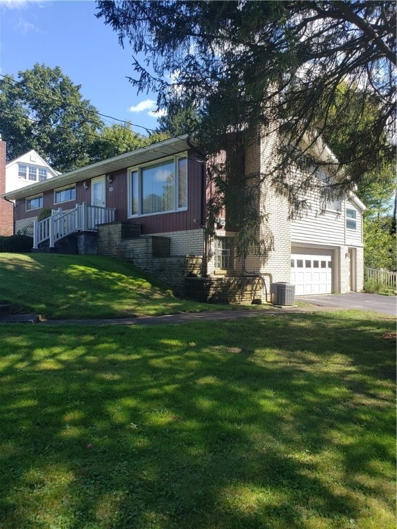 view of front of house with a front lawn, brick siding, driveway, and an attached garage