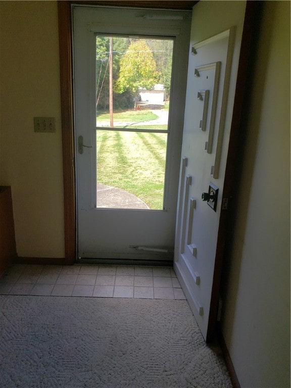 doorway to outside with light tile patterned floors and plenty of natural light