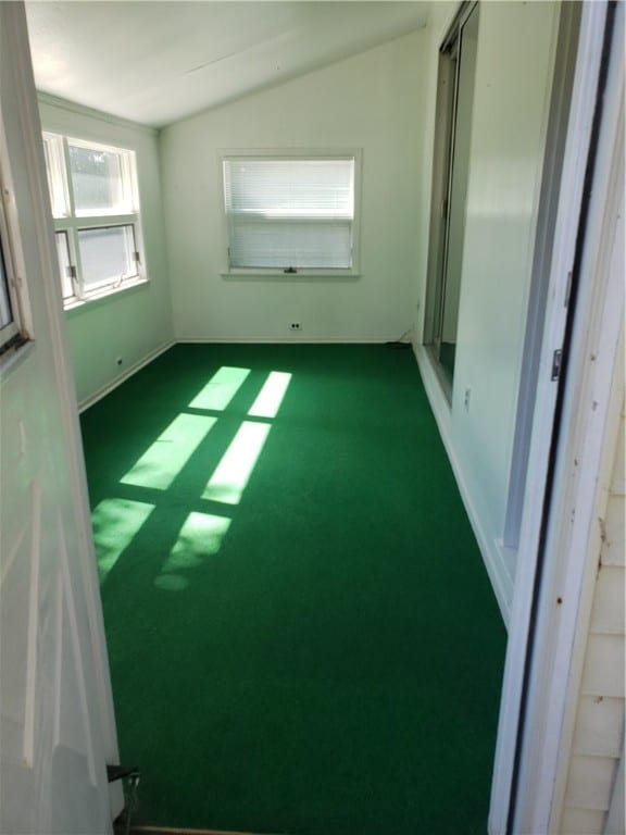 carpeted empty room featuring lofted ceiling