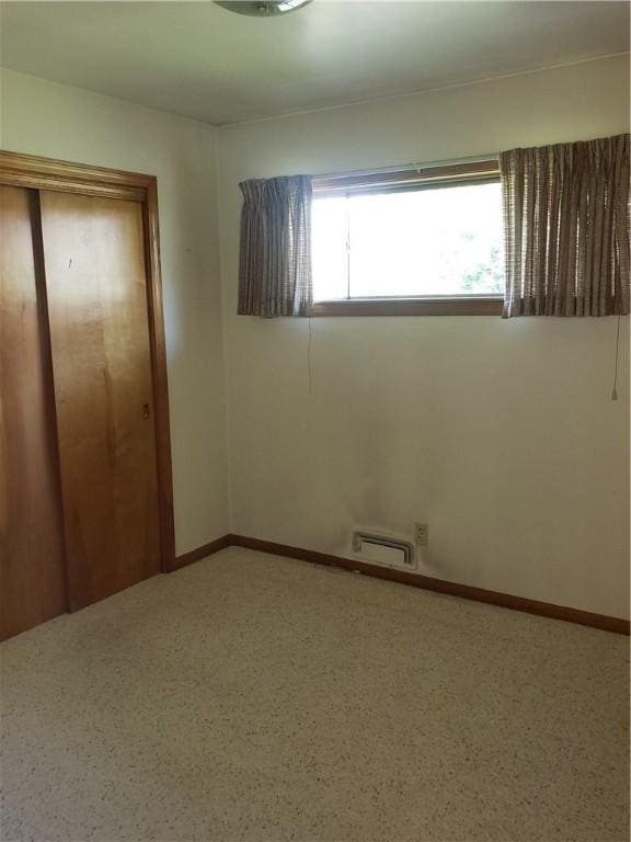 unfurnished bedroom featuring a closet and baseboards