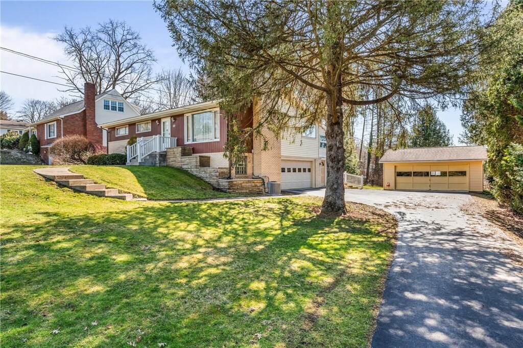 1 Evergreen Dr, Hempfield Twp, PA 16125 - view of front facade with a front lawn, driveway, an outdoor structure, and a garage