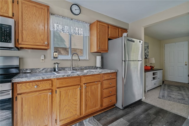 kitchen with appliances with stainless steel finishes, dark wood-type flooring, and sink