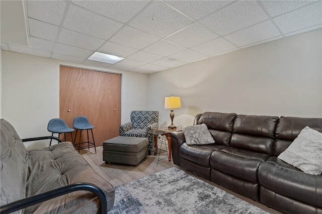 living room with a drop ceiling and light hardwood / wood-style floors