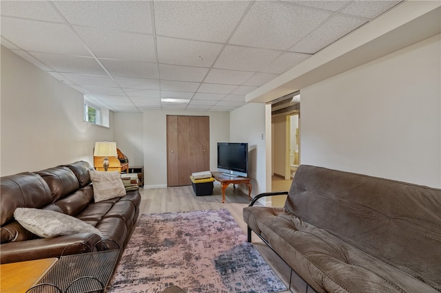 living room with a paneled ceiling and light hardwood / wood-style floors