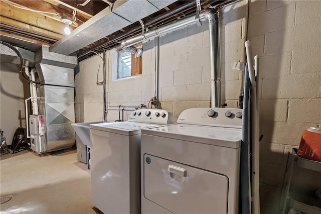 laundry area with heating unit and washer and clothes dryer