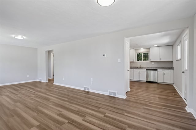 unfurnished living room featuring hardwood / wood-style floors and sink